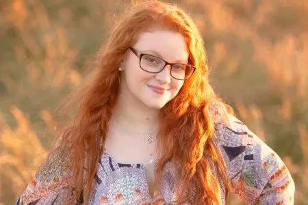 Руда дівчина з пишними формами в полі роздягається (ФОТО)